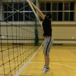 ネットの白帯に沿って腕を相手コート側に出していく